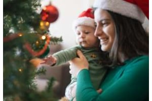 maman et bébé devant le sapin de noel